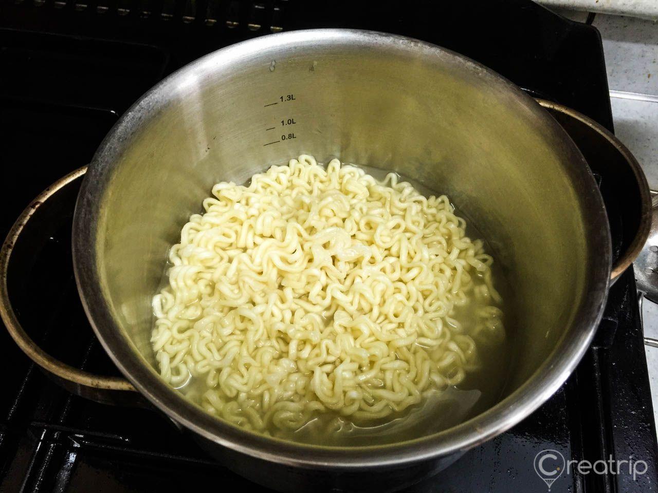 辣炒雞麵的煮水被濾掉，鍋中留下適量的水，為下一步的調味做準備，小心保持水量。