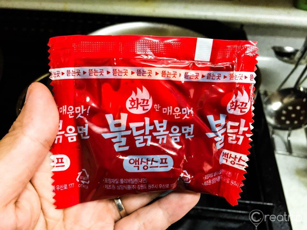 在鍋中倒入辣炒雞麵的液體調料包，濃厚的紅色醬汁攪拌著熱騰騰的面條，散發出誘人的香味。