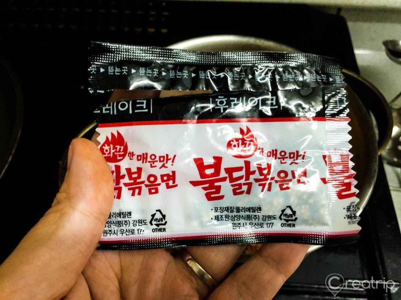 將黑白色的乾料包加入辣炒雞麵中，攪拌均勻，讓面條充分吸收濃烈的調味汁。