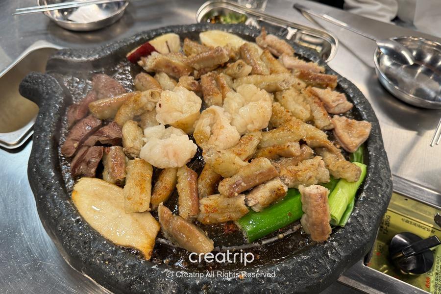 A sizzling platter of assorted grilled intestines including juicy beef and pork, served at Wuri Small Yellow Cattle Barbecue, a newly opened all-you-can-eat grill in Seoul's Konkuk University area.