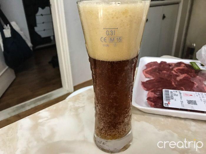 倒入酒杯的江西啤酒，彰顯其深色和少許苦味的特色