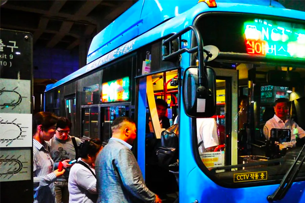 Passengers boarding a Korean city bus, illustrating a typical bus boarding experience in South Korea.