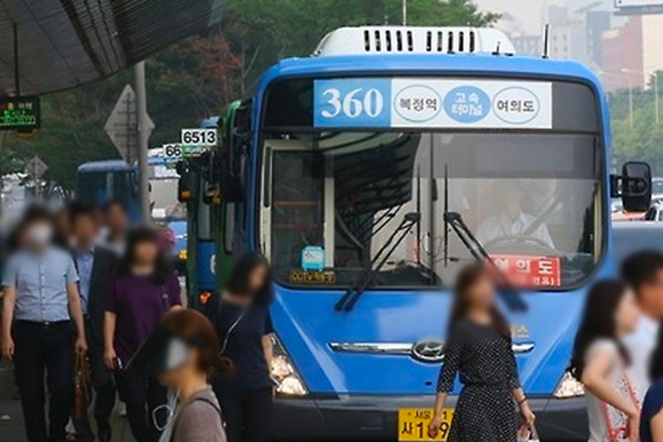 Image of a Korean city bus at a busy Seoul street, showing blue buses and passengers waiting to board. Captured by 브런치.