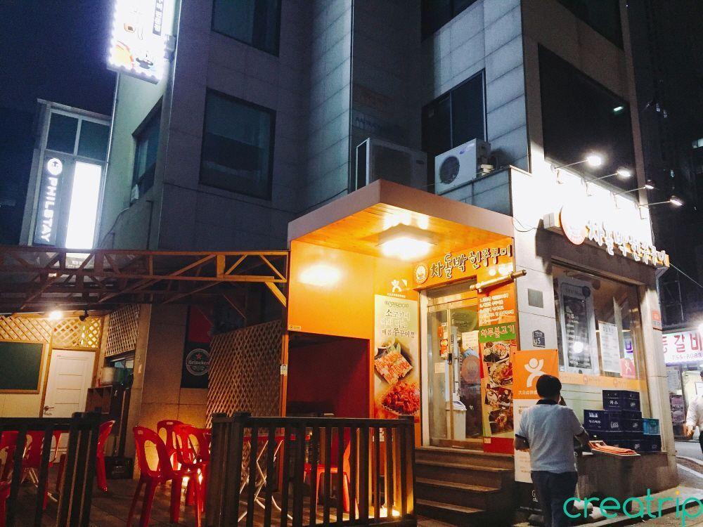 Exterior view of Phi Stay Hotel located near Myeongdong Station exit 4, where Cha Jang Bul Gogi restaurant is situated.