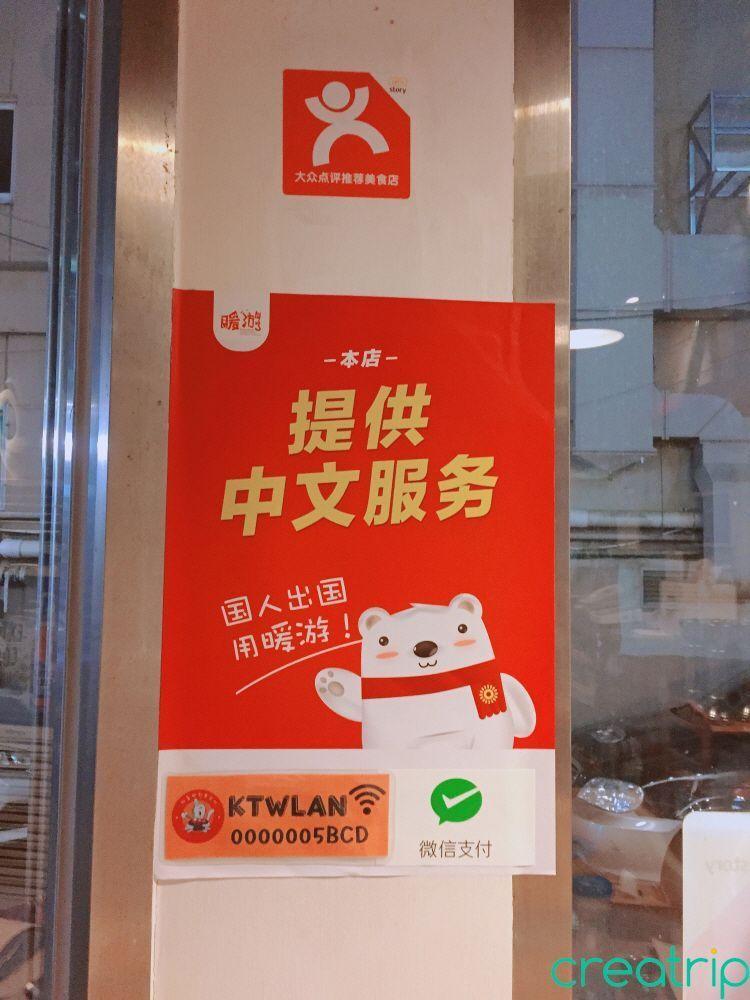 Sign indicating that Fatty Octopus restaurant offers free Wi-Fi and Chinese-speaking staff.