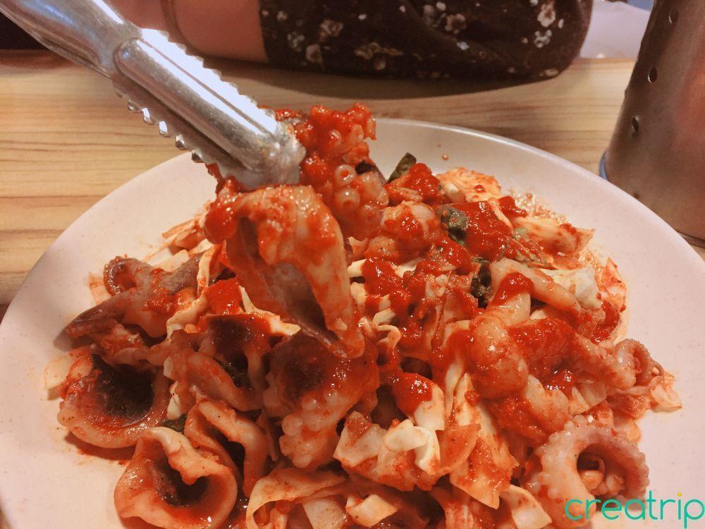 Cooked octopus at Fatty Octopus restaurant in Myeongdong with garnish on side.