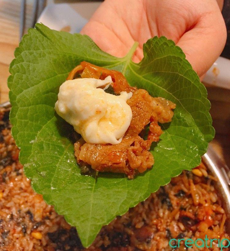 Small beef slices and octopus topped with cheese in a lettuce wrap at Myeongdong's Fatty Octopus restaurant.