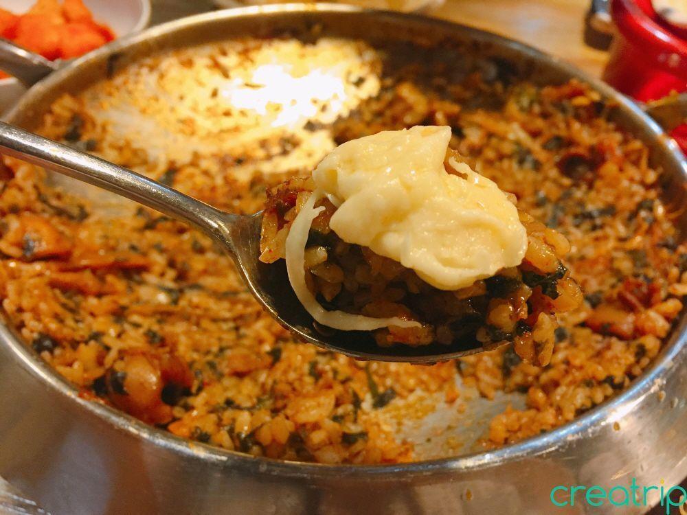 Myeongdong's Fatty Octopus restaurant's customers savoring fried rice with additional garnish.