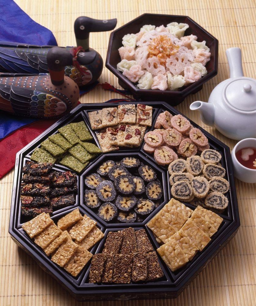 色彩繽紛，擺在黑色八角盤中的韓菓和유과，彰顯了韓國精緻糕點文化。