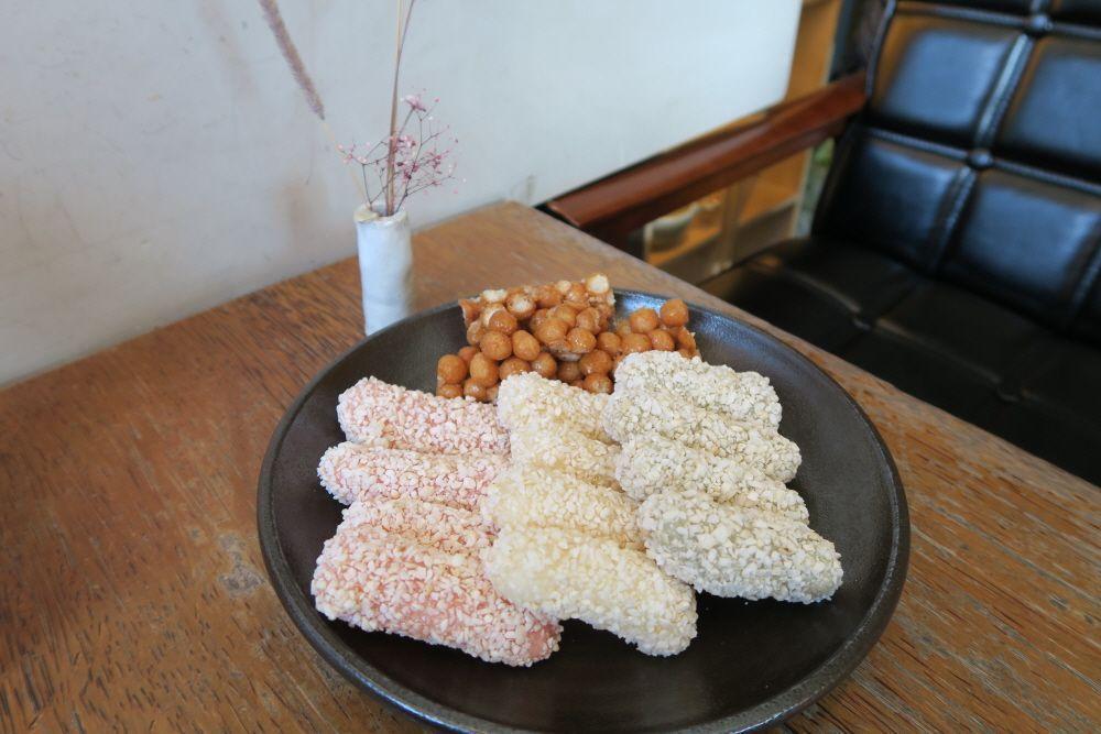 粉紅與米黃色的韓菓，放在木製託盤上，展示了韓國傳統甜點的魅力。