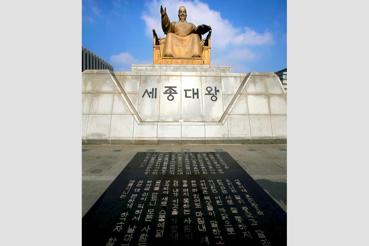 Front view of King Sejong's statue with inscription in Korean, commemorating his contributions to Hangul.