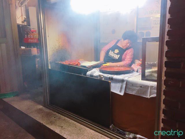 无名烧烤店内顾客众多，享用美味的烧烤串和热汤。