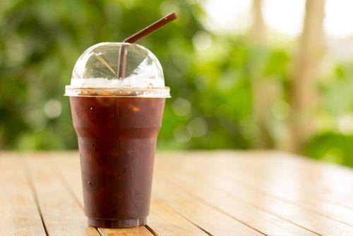 Iced Americano in a plastic cup on a wooden table, a popular coffee choice representing South Korean coffee preference.