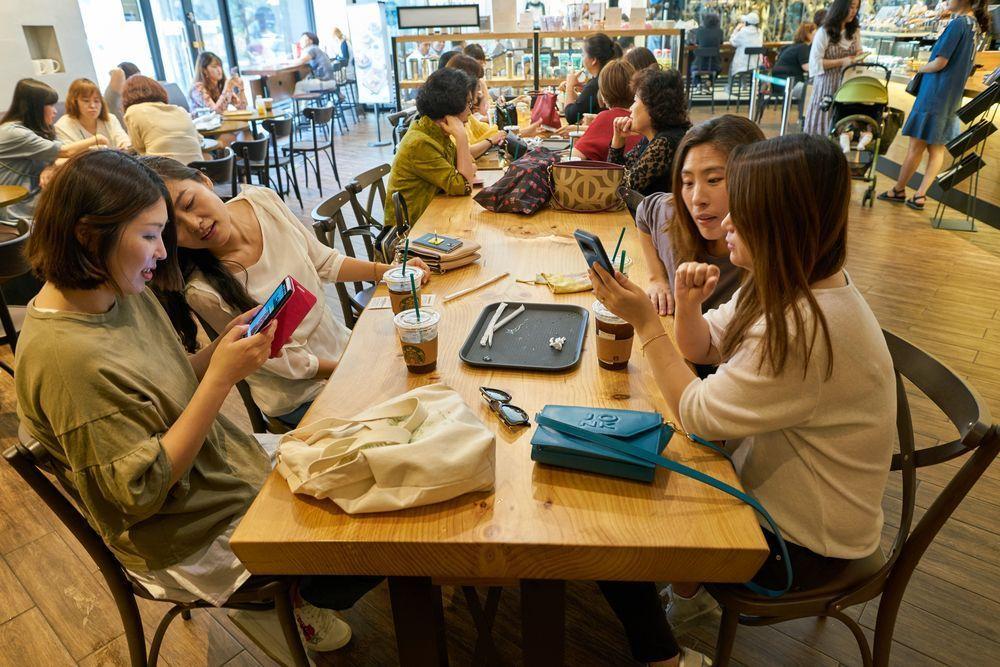 People socializing in a contemporary South Korean coffee shop, demonstrating the vibrant cafe culture in the country.