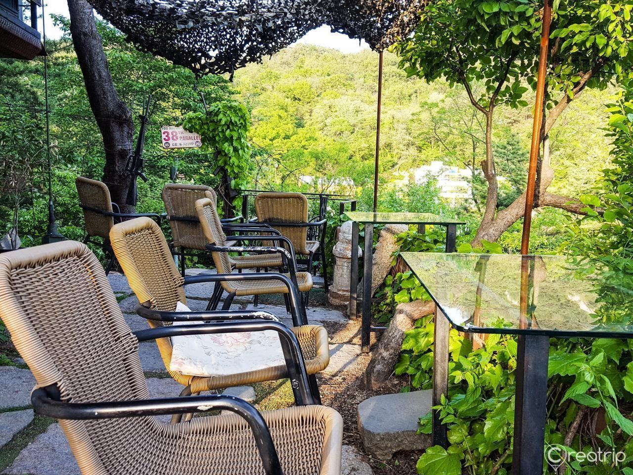 户外座椅和桌子，位于山脊咖啡馆，绿树环绕，享受舒适的下午时光。