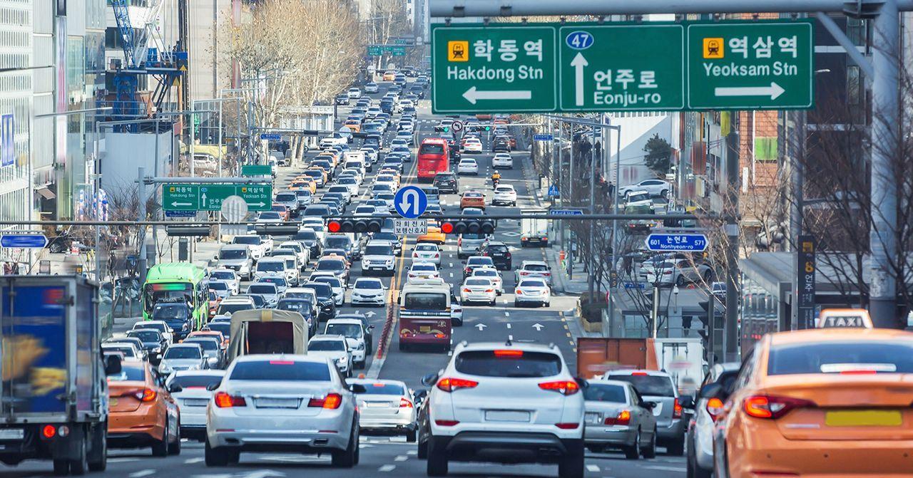 Image of a busy Seoul street with heavy traffic and street signs.