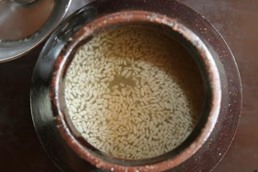  동동주를 담고 있는 항아리의 상단 뷰. 맑은 액체 사이에 뜬 쌀알들이 보인다.