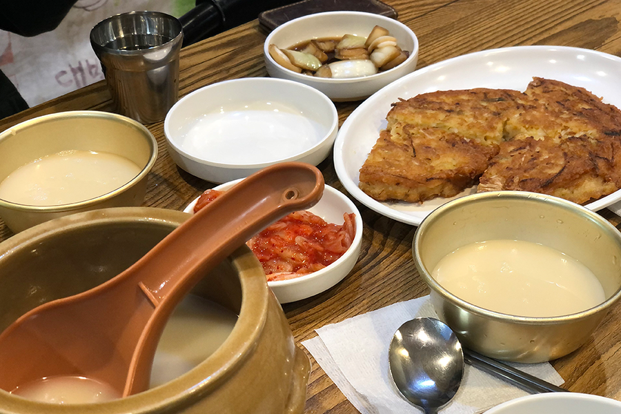 다양한 한식 전통 음식과 막걸리가 차려진 테이블. 파전과 곁들여 먹기에 완벽한 음료 조합.