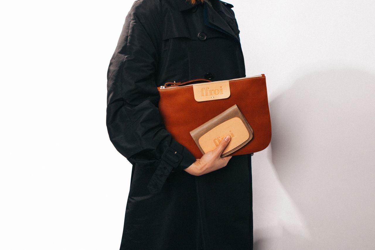 A person holding a unique leather bag and wallet from ffroi, showcasing the brand's meticulous craftsmanship and quality materials.