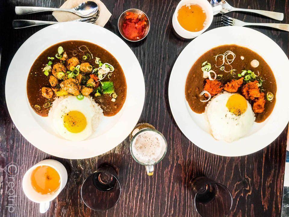 Two plates of Korean-style curry from Meemee’s Curry in Seongsu-dong, served with fried eggs and a variety of toppings.