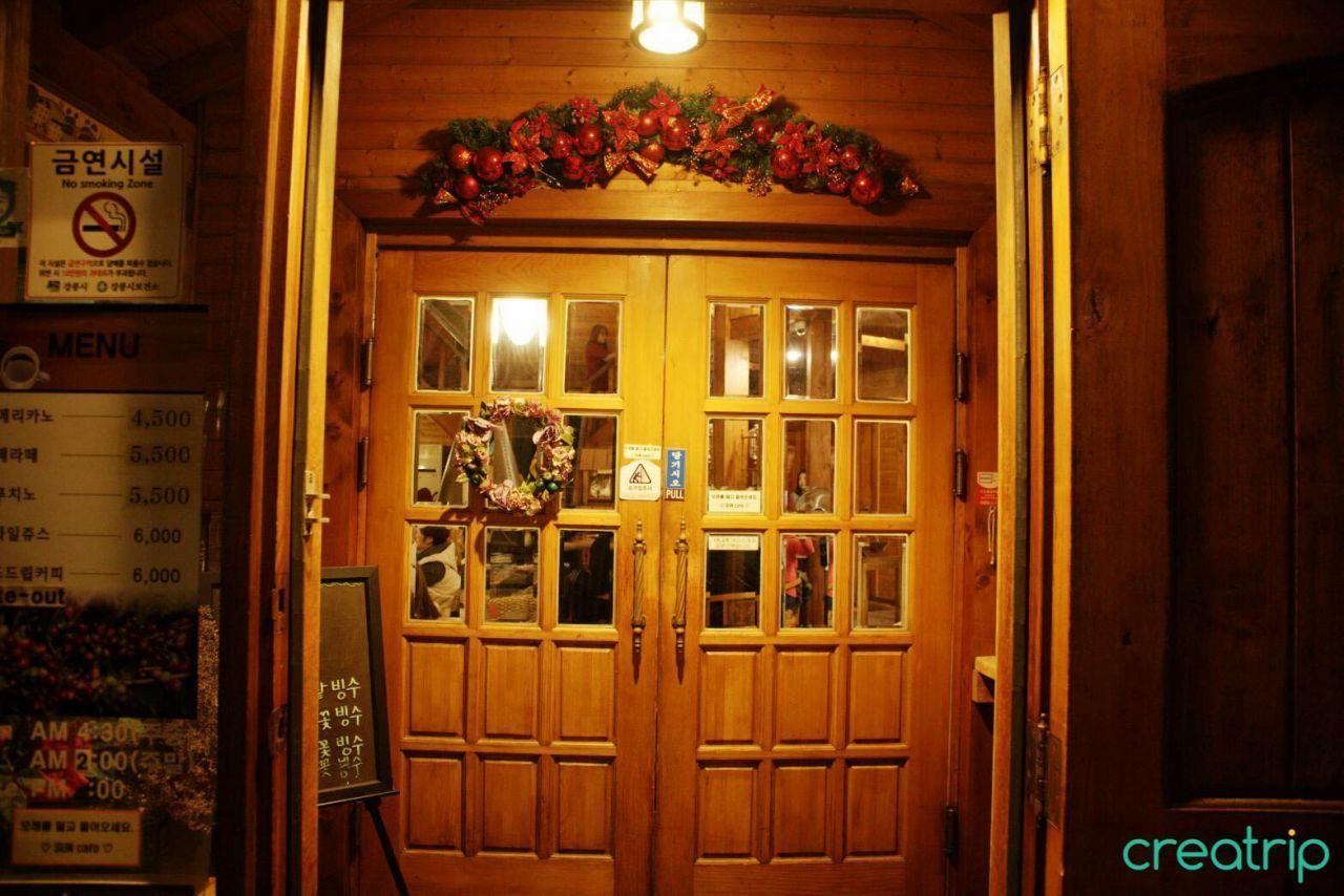 咖啡廳內部的夜景，顧客們圍坐在桌旁，享受溫暖氛圍。