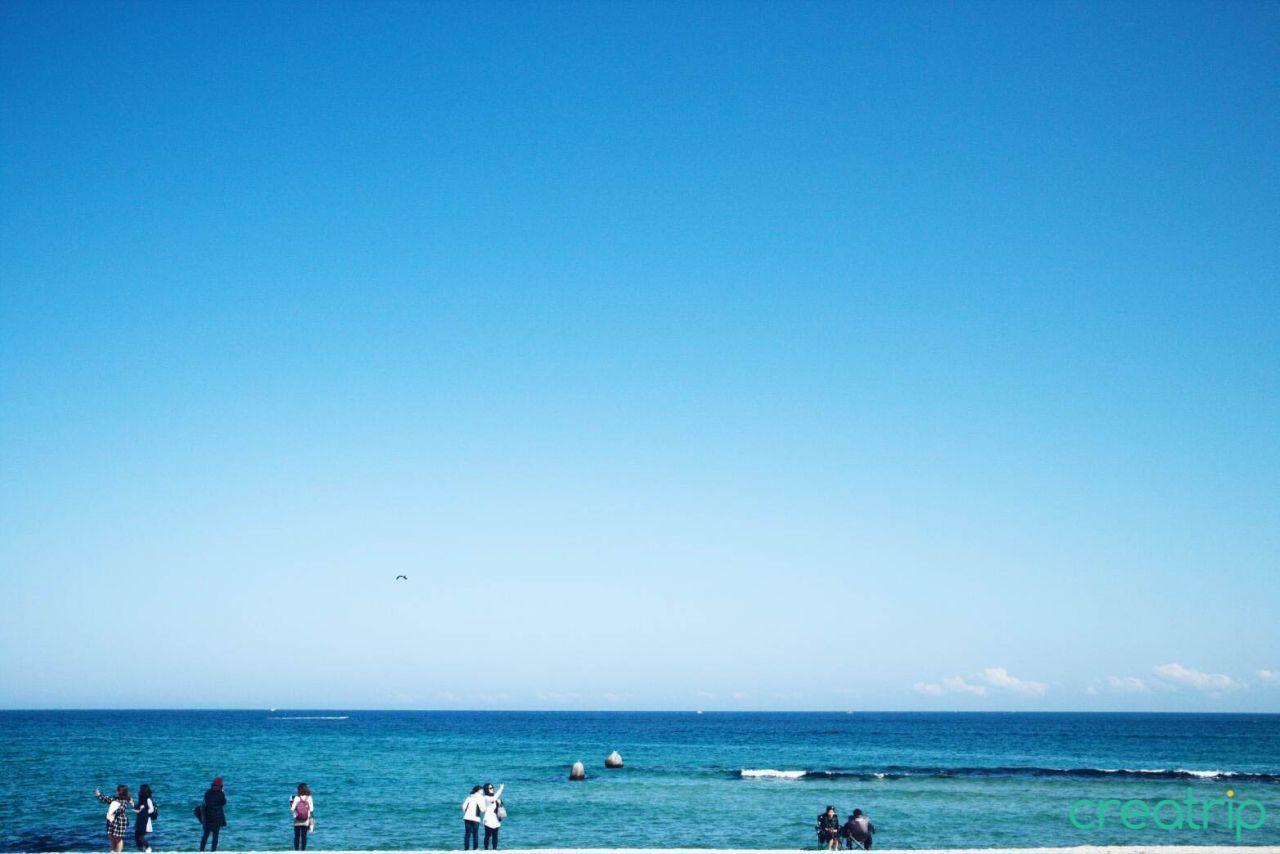 安木海邊的大海，在明亮的陽光下波光粼粼，沙灘寬廣。