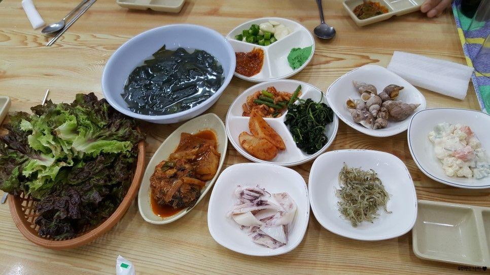 桌上擺滿韓式小菜和海鮮拼盤，料理色彩豐富誘人。