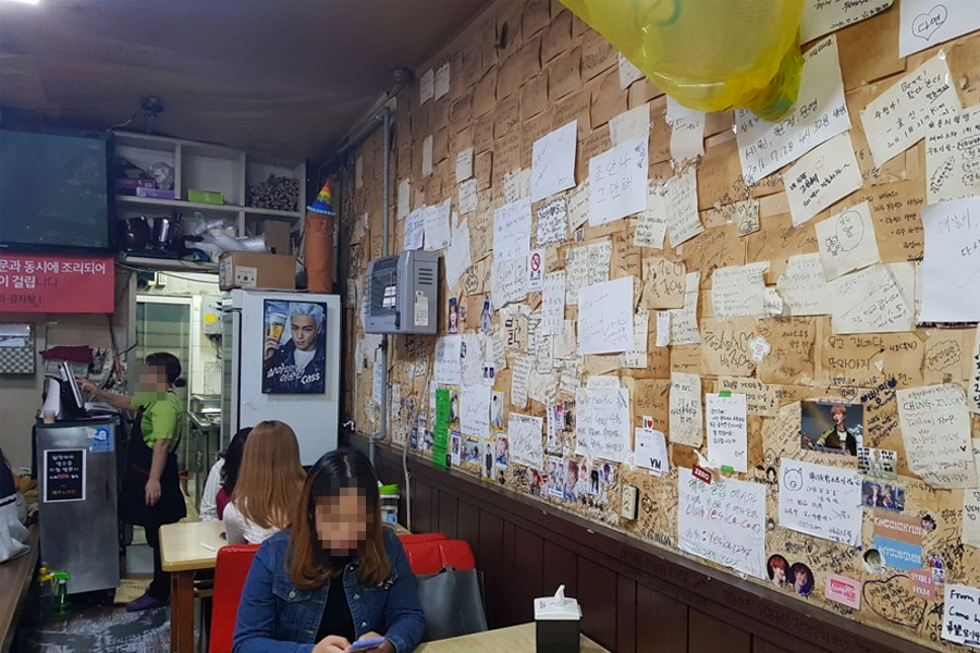 餐厅内部墙壁上贴满顾客留言和签名的纸条,气氛温馨,墙壁上还可以看到一些K-POP明星的照片和签名。