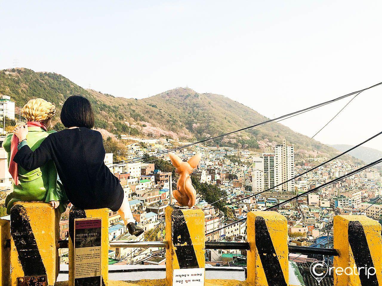 부산 감천문화마을의 대중적인 아름다움을 보여주는 장면으로, 멀리 보이는 도심과 함께 여유로운 분위기를 연출합니다.