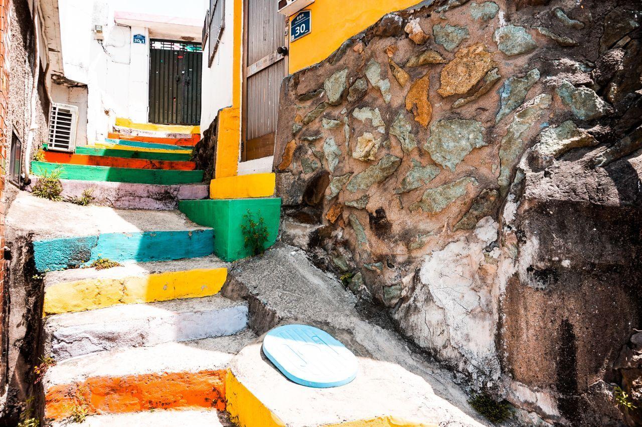 통영 서피랑 벽화마을의 활기찬 거리. 서로 다른 색조의 벽화가 있는 매력적인 마을의 일상.