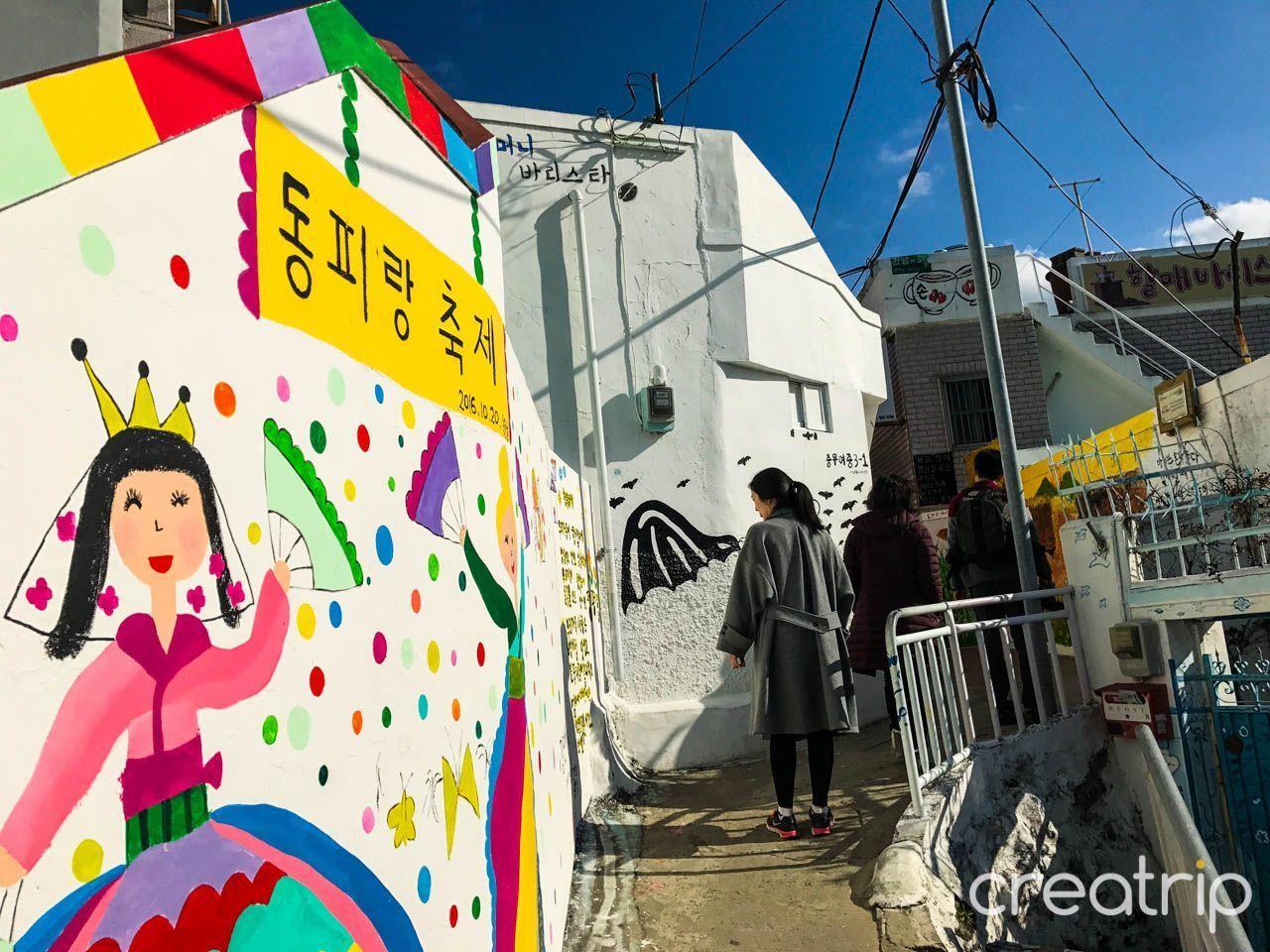 통영 동피랑 벽화마을의 유쾌한 장면을 담은 벽화. 간단한 터치로 표현된 삽화들이 거리를 장식하고 있습니다.