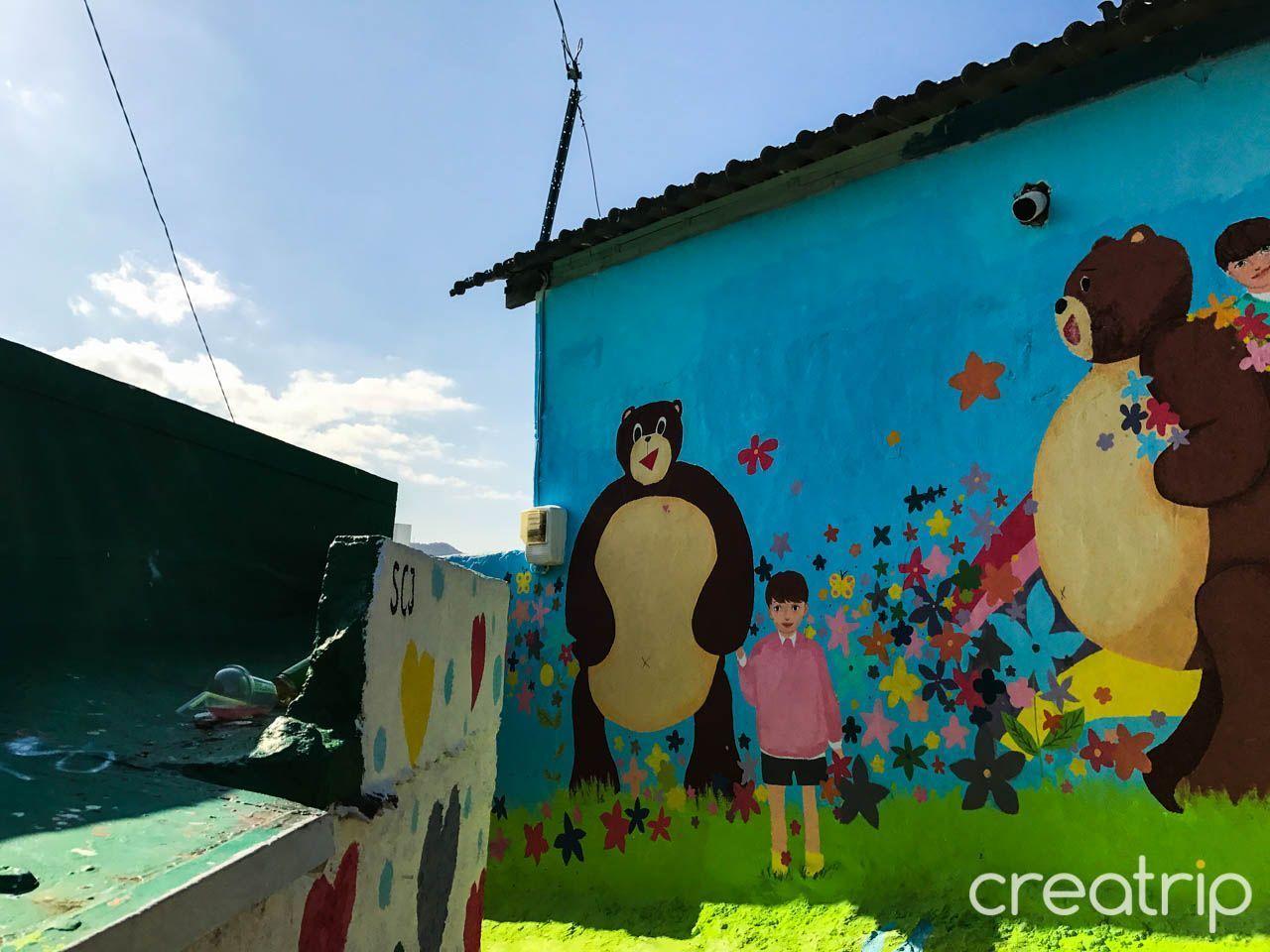 통영 동피랑 벽화마을 이미지로 알록달록한 계단과 다양한 색상의 벽화가 있는 마을 전경.