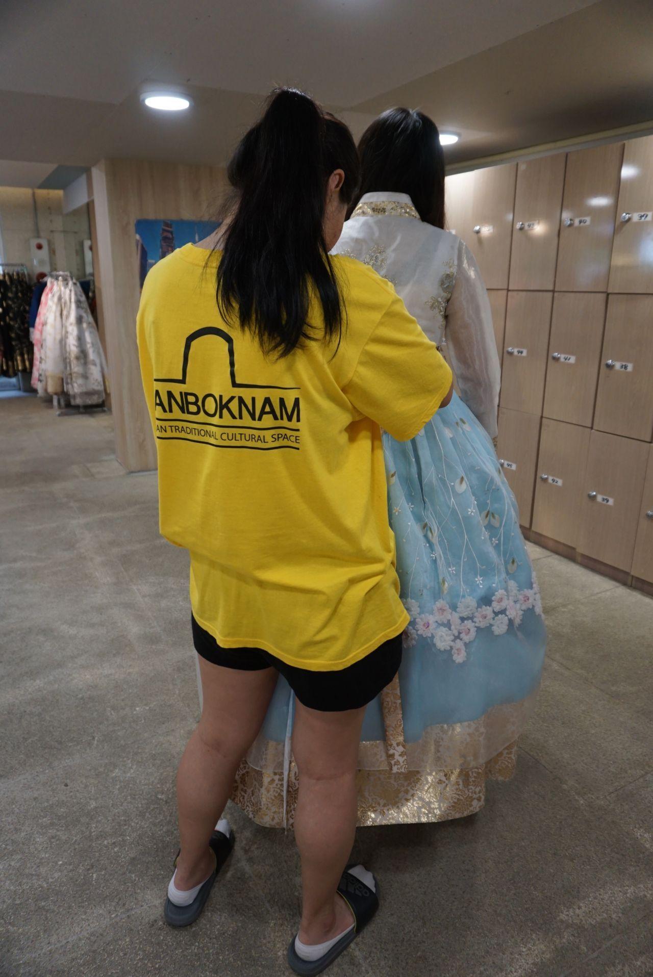 Tourists enjoying a Hanbok experience in Jeonju, browsing through an array of traditional dresses.