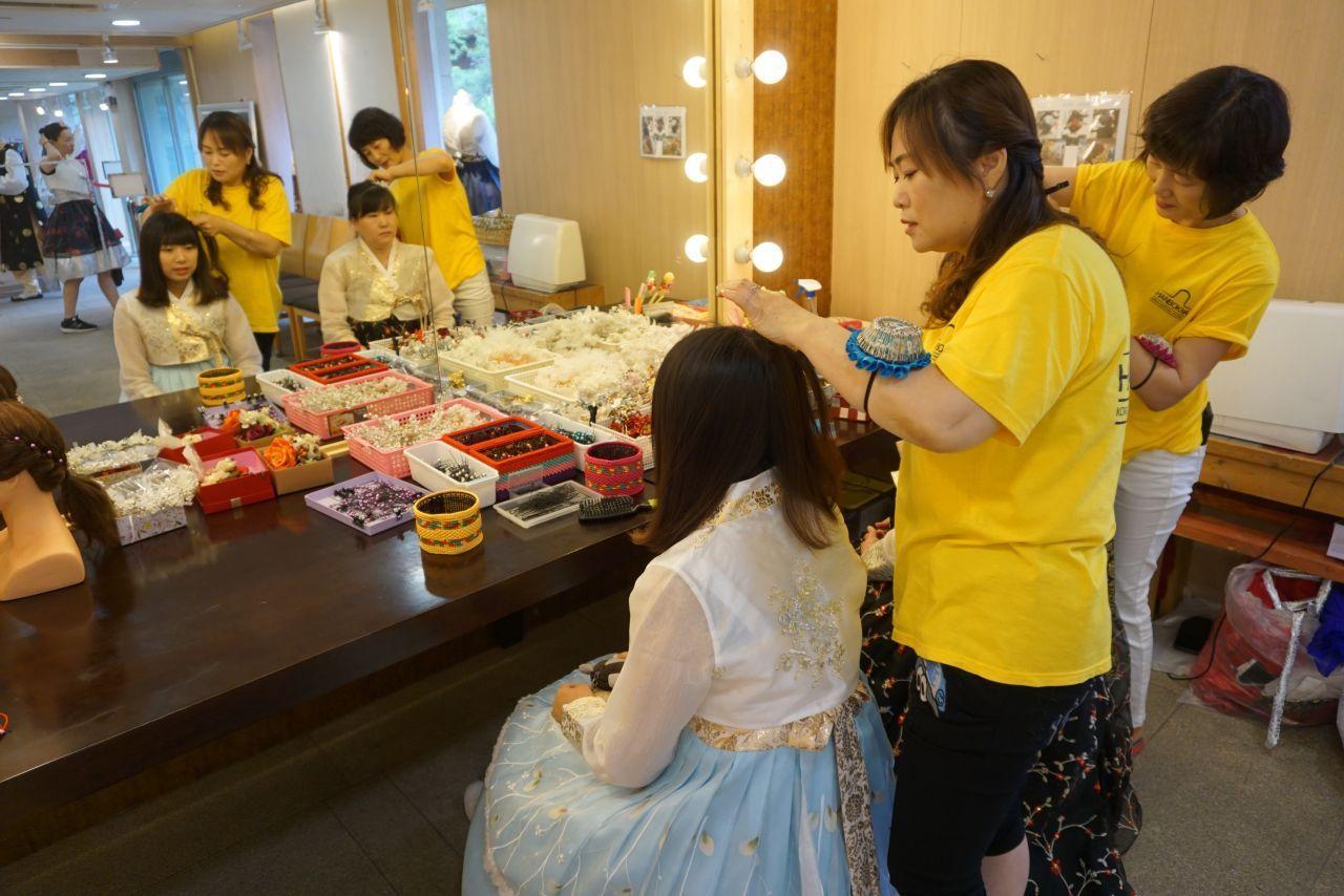 A stylist assisting with hair styling and accessories at Hanboknam, enhancing the Hanbok wearing experience for visitors.