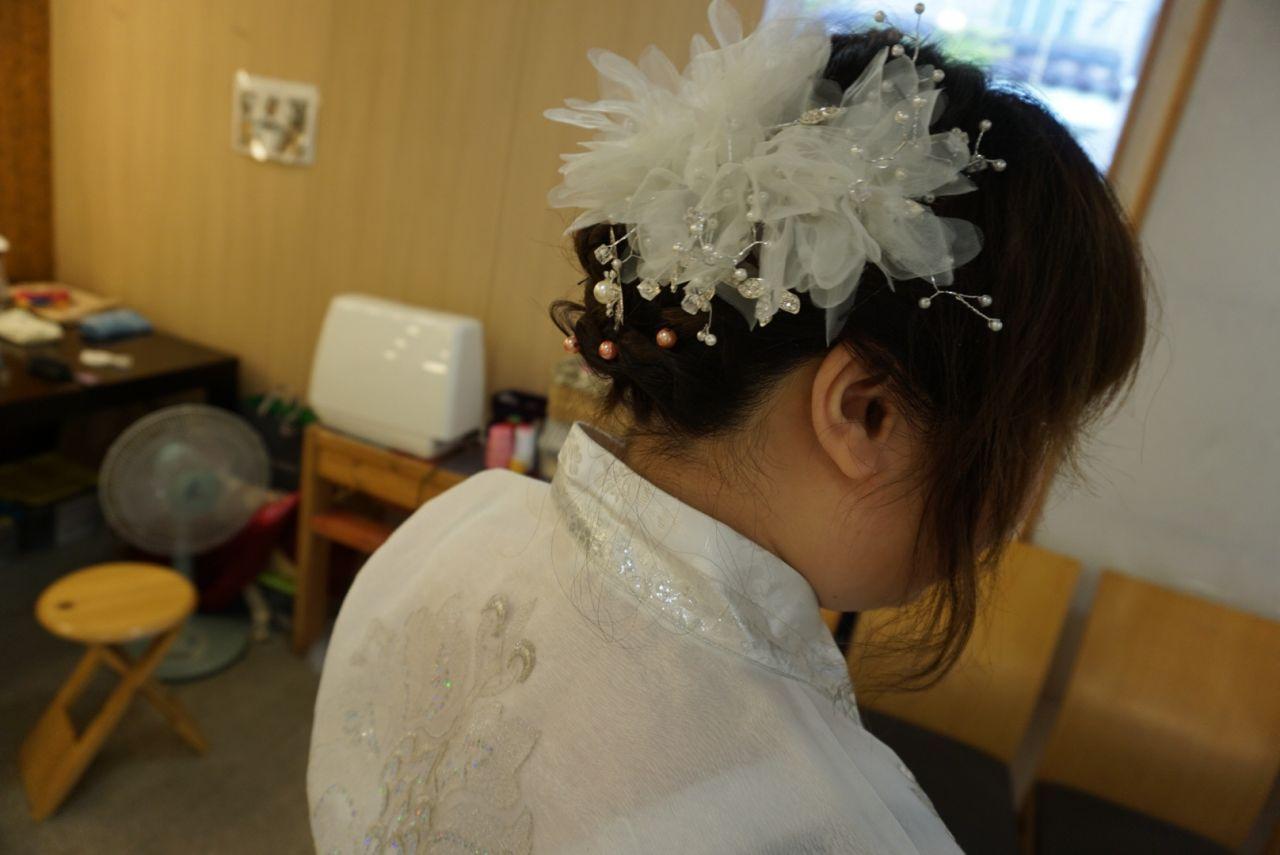 Visitors trying on Hanbok at Hanboknam, Jeonju, as friendly staff assist with measurements and styles.
