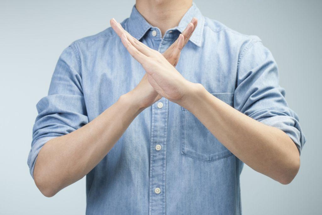 一名男子比划出禁止的手势,表明拒绝或阻止的意图。