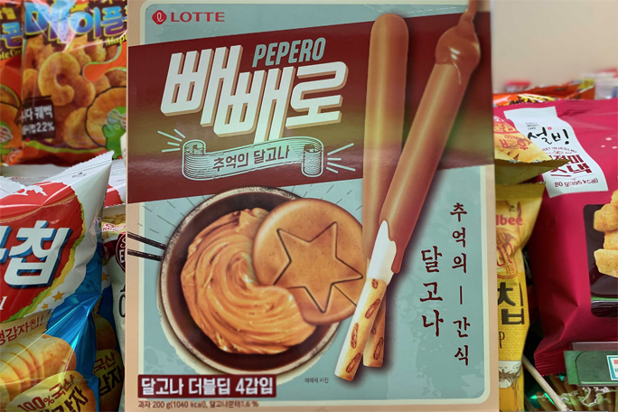 展示了一堆采用不同包装设计的Pepero，这些设计包括流行卡通角色如小黄人。