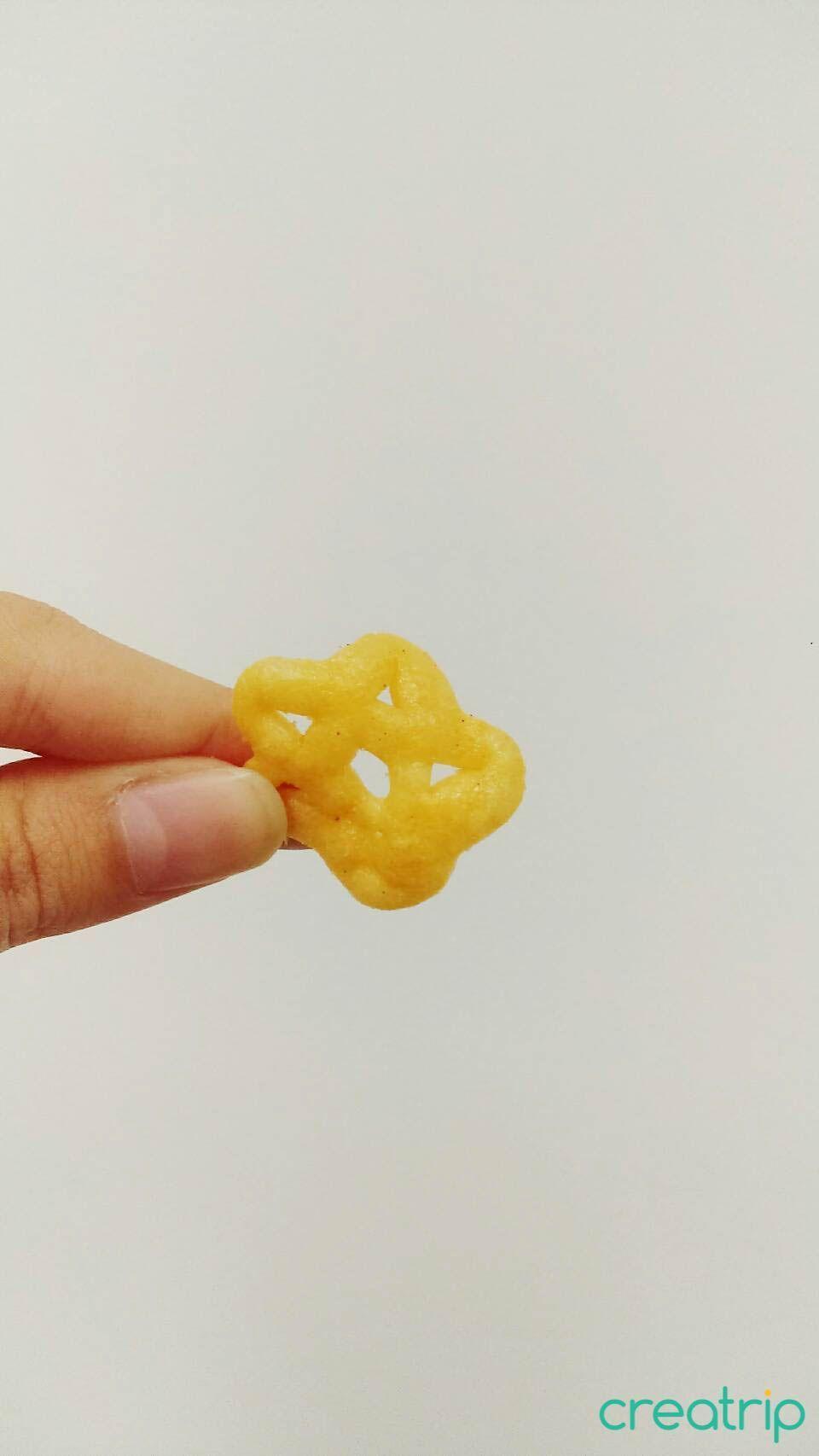 Hand holding a star-shaped spicy bulgogi chip from CU convenience store snack pack