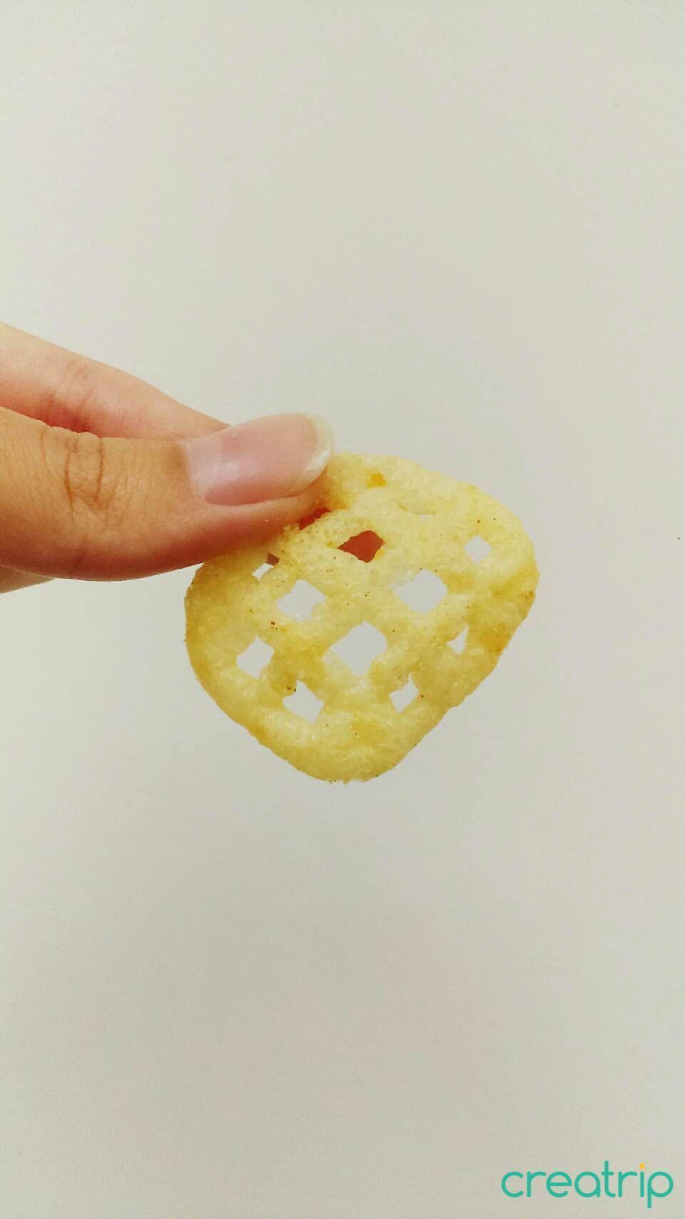 Hand displaying a mesh grid design spicy bulgogi chip from CU Korean snack packaging