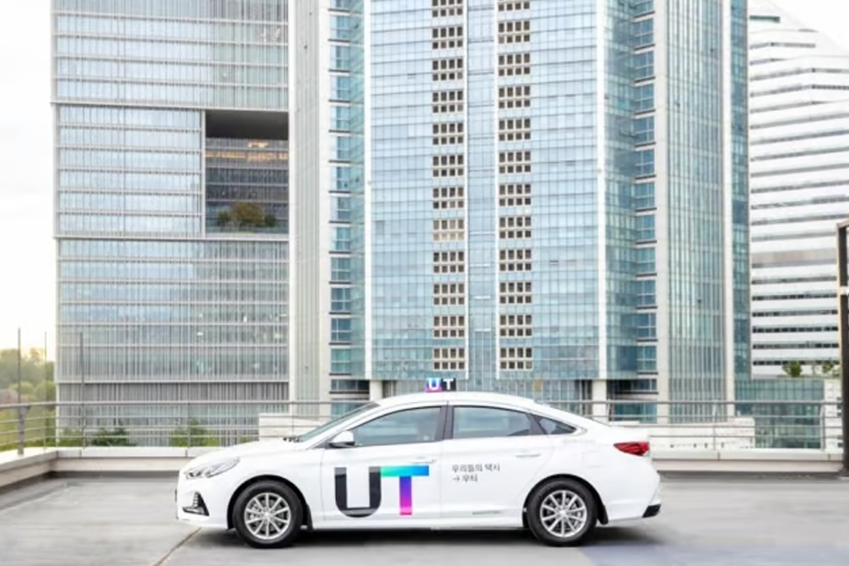 UT taxi service vehicle parked in front of modern buildings, available for ride-hailing in South Korea.