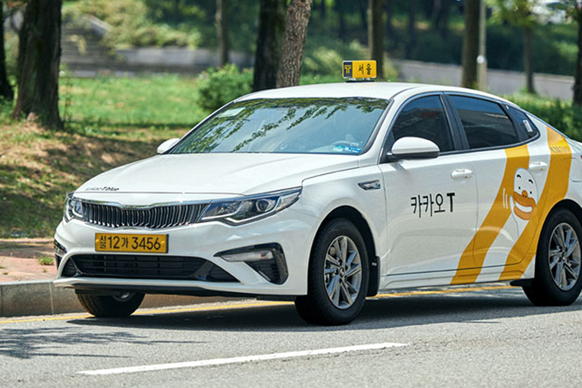White Kakao Taxi vehicle on a road, showcasing the convenient taxi service in South Korea.