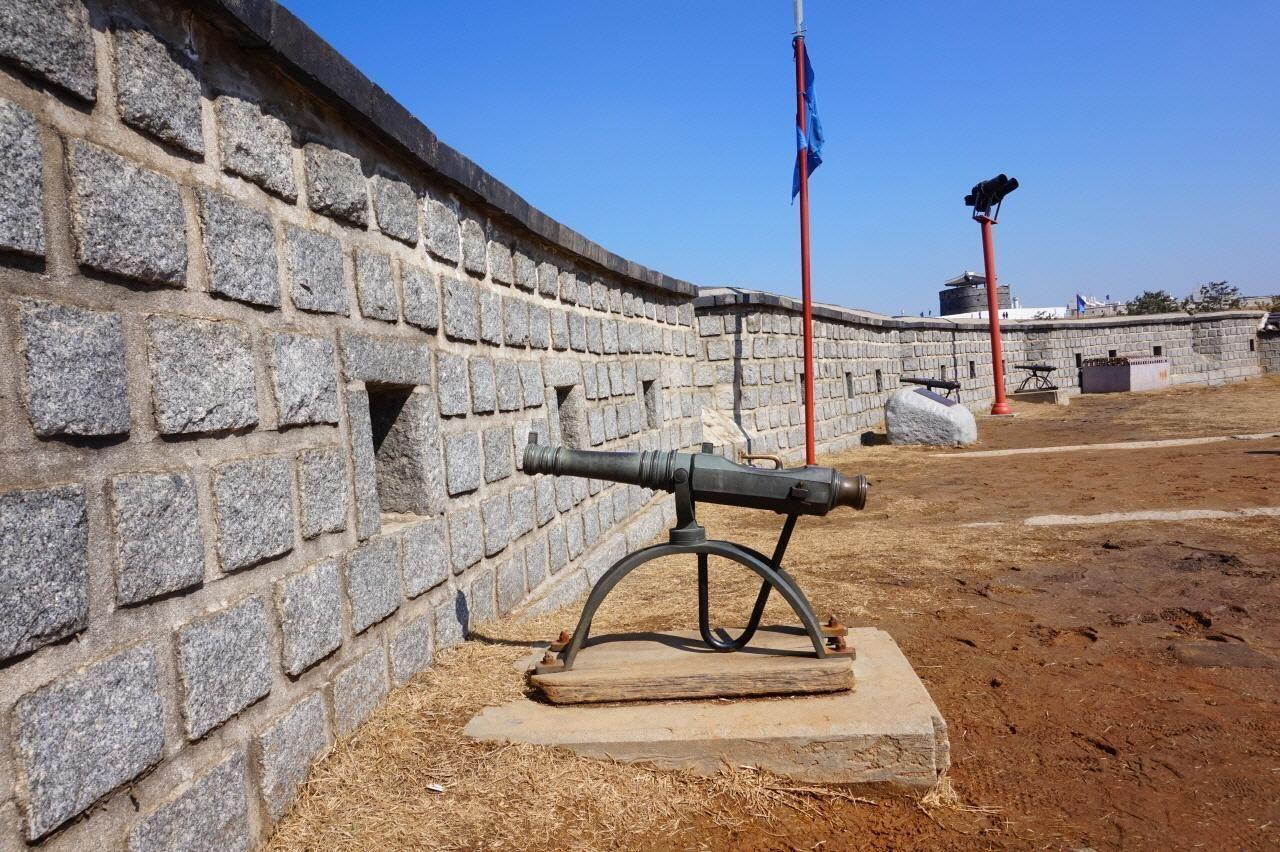 水原華城的一部分和大砲展示，整個畫面將石牆和青天的清晰度完美結合。