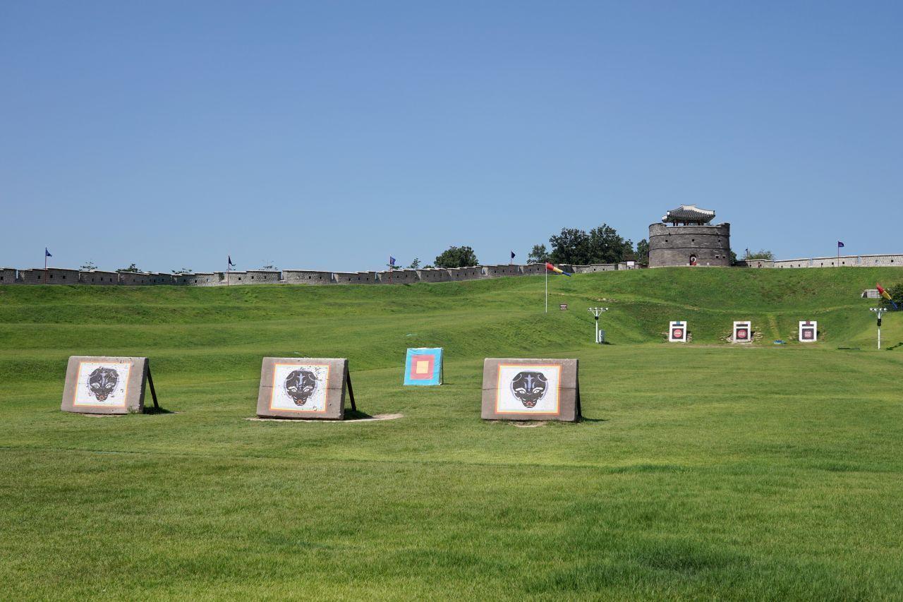 蒼龍門附近的射箭靶場，背景是廣闊的綠色草坪和清晰的藍色天空，幾個箭靶有序排放。