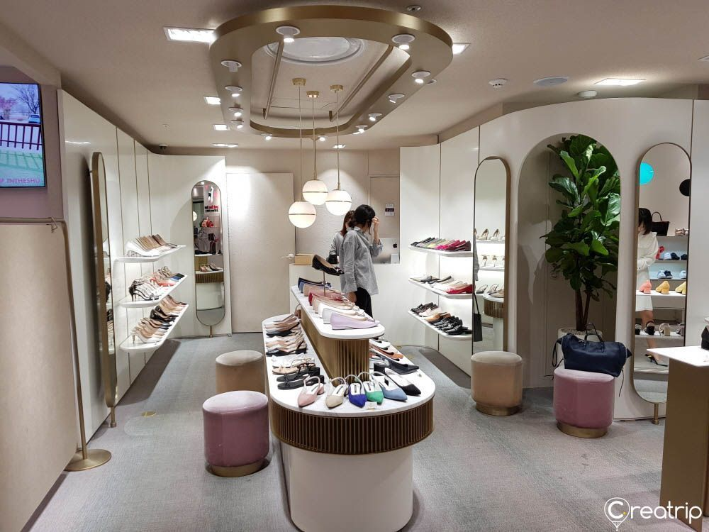 韓國某時尚鞋店內部展示，擺放著各式各樣的鞋子和鏡子。