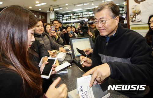 記者會上，工作人員為一位顧客簽署書本。