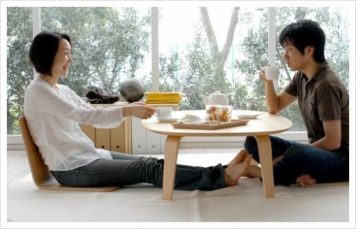 坐式文化空間內，兩位成年人坐在低矮的桌子旁享用飲品。