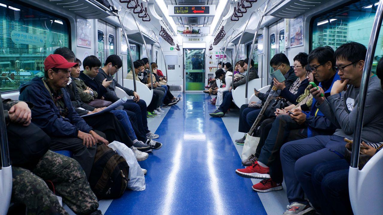 韓國地鐵車廂，乘客全神貫注地使用智能手機。」