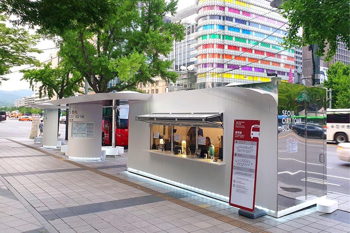 Seoul City Tour Bus ticket booth at Gwanghwamun Station with a modern building in the background