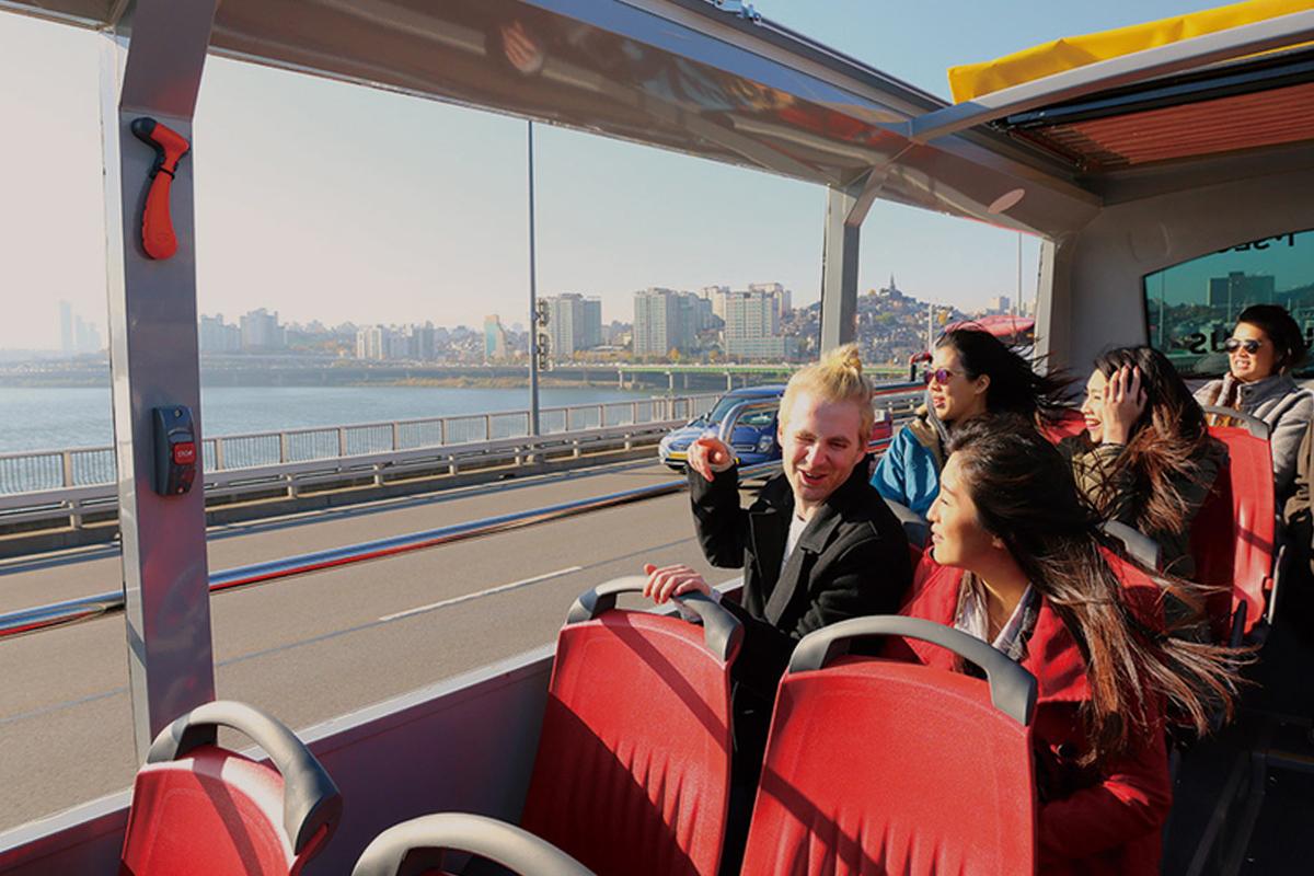 Interior of the Seoul City Tour open-top bus overlooking Seoul's Han River with clear skies