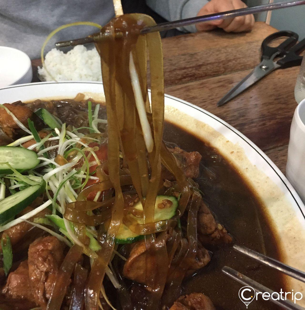 宽粉条炖在韩式酱汁中，搭配炖熟的马铃薯。